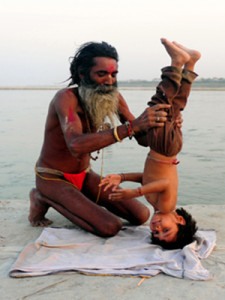 An Indian Hindu Sadhu (holy man) poses his adopted child in a yoga headstand on the banks of the Sangam in Allahabad on April 30, 2013.  Yoga, which means union in Sanskrit, is a family of ancient spiritual practices and also a school of spiritual thought from the Asian subcontinent, where it remains a vibrant living tradition and is seen as a meaning of enlightenment. AFP PHOTO/ SANJAY KANOJIASanjay Kanojia/AFP/Getty Images